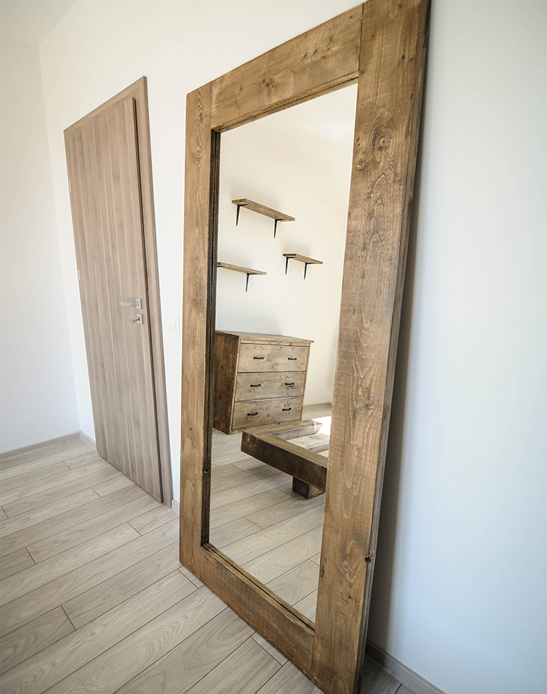 O oglinda langa perete intr-o camera de apartament