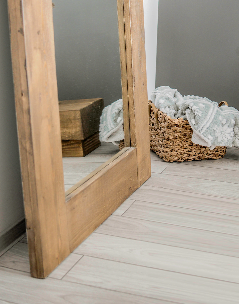 O oglinda langa perete intr-o camera de apartament