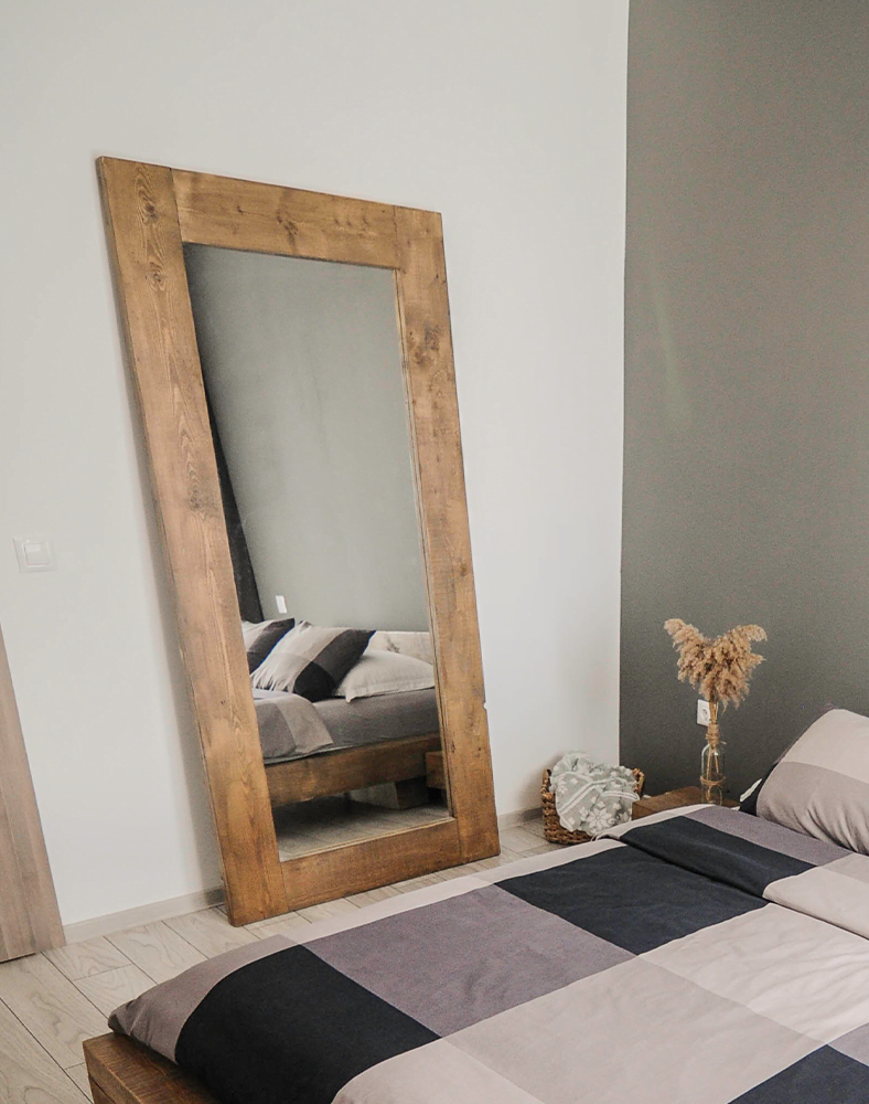 O oglinda langa perete intr-o camera de apartament