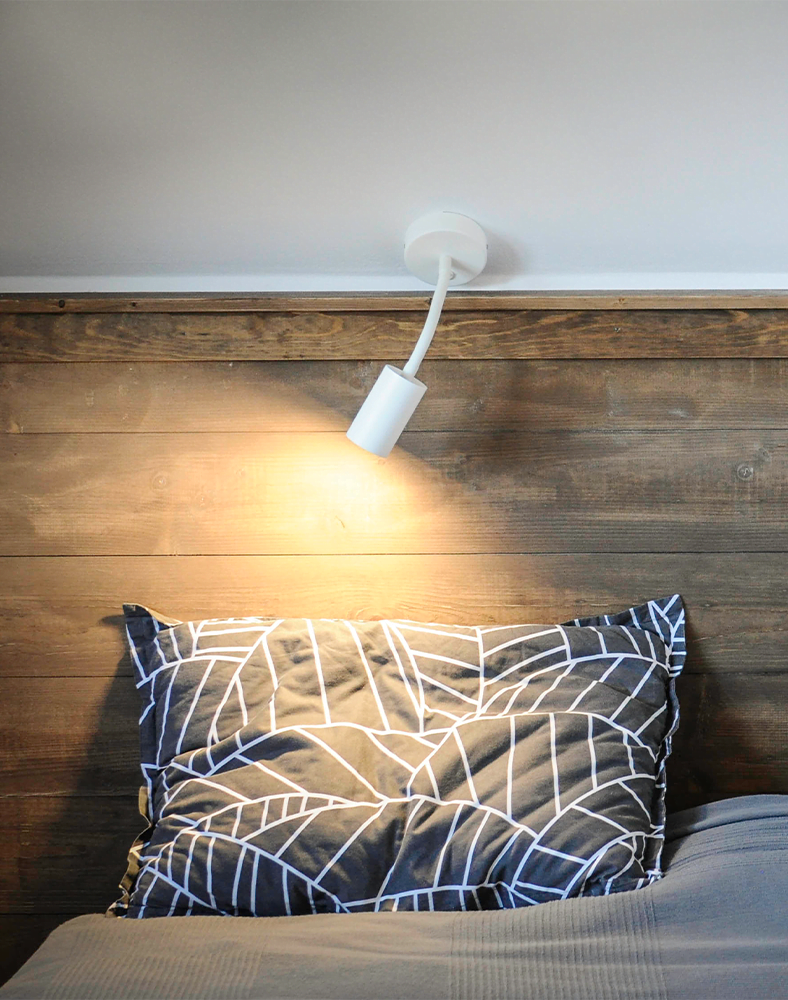 Un pat cu spatar, o perna si lampa