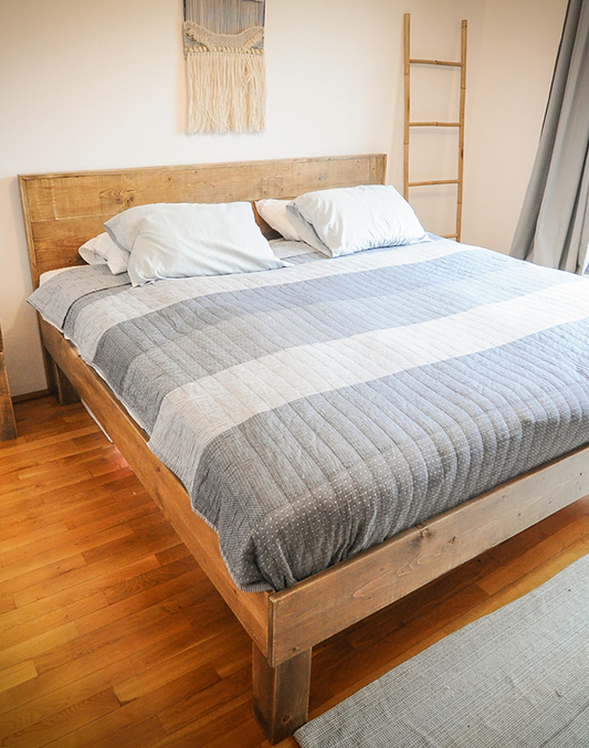 Un pat rustic din grinzi in camera pe langa pe langa o scara