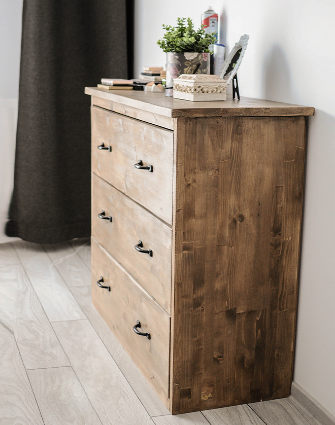Comodă din lemn, cu design simplu și funcțional, prevăzută cu sertare pentru depozitare, potrivită pentru dormitor sau living.