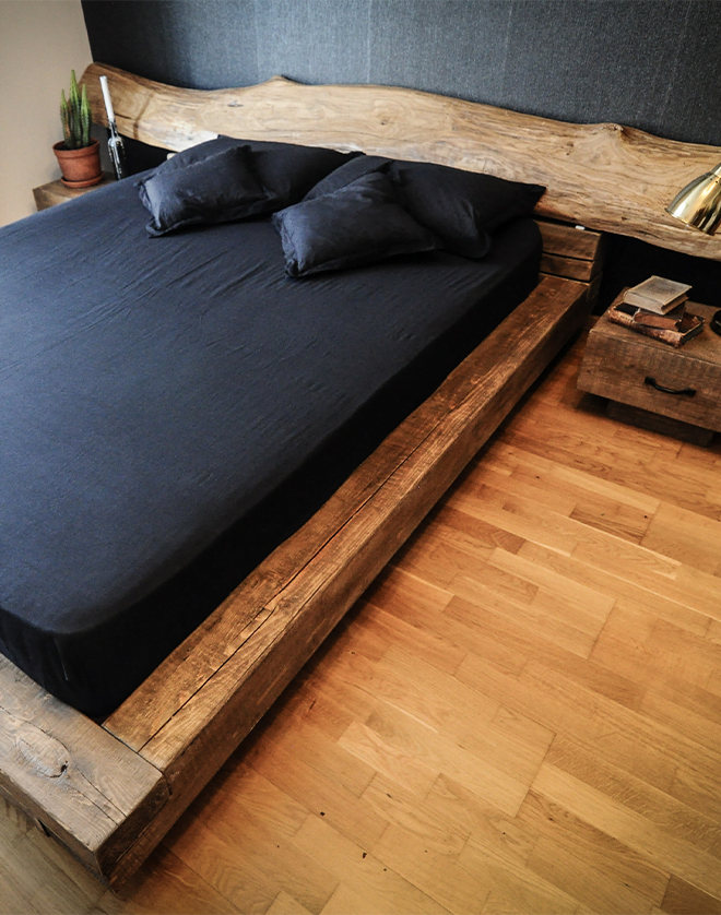 Pat din lemn în stil rustic, cu design natural și construcție solidă, realizat din materiale durabile, ideal pentru un dormitor cald și primitor.